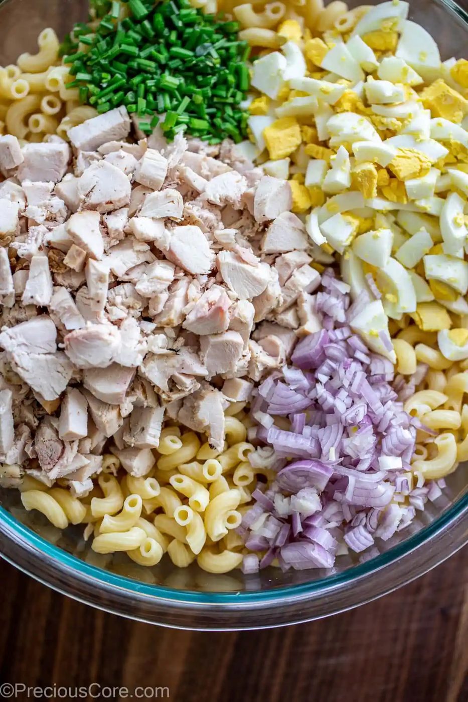 Ingredients for macaroni chicken salad in a large bowl.