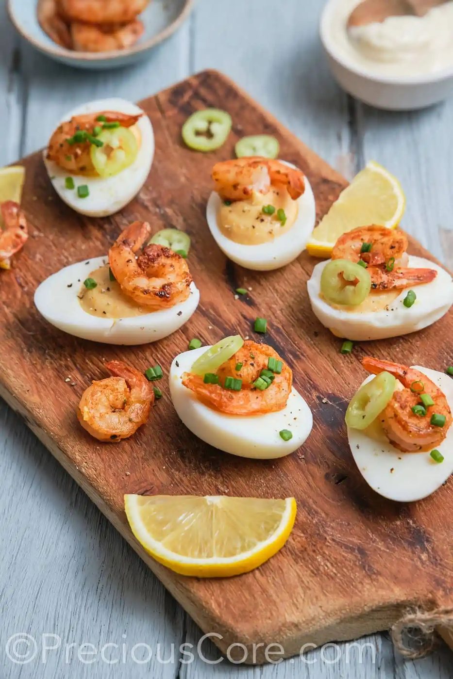 Side shot of satisfying-looking deviled eggs topped with shrimp.