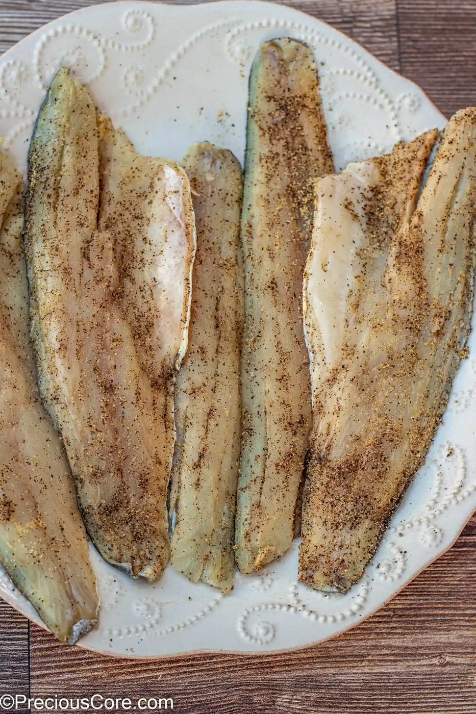 Seasoned sea bass on a large plate.