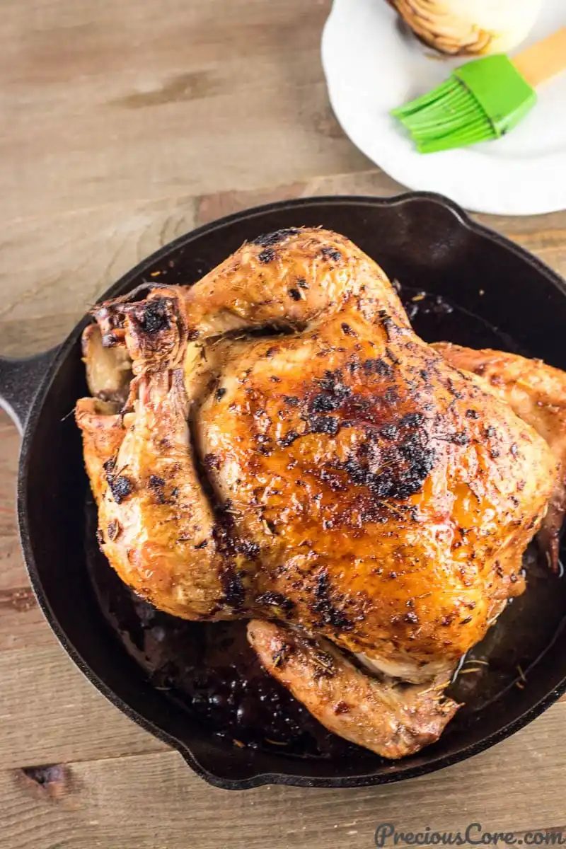 A whole roasted chicken in a cast iron skillet.