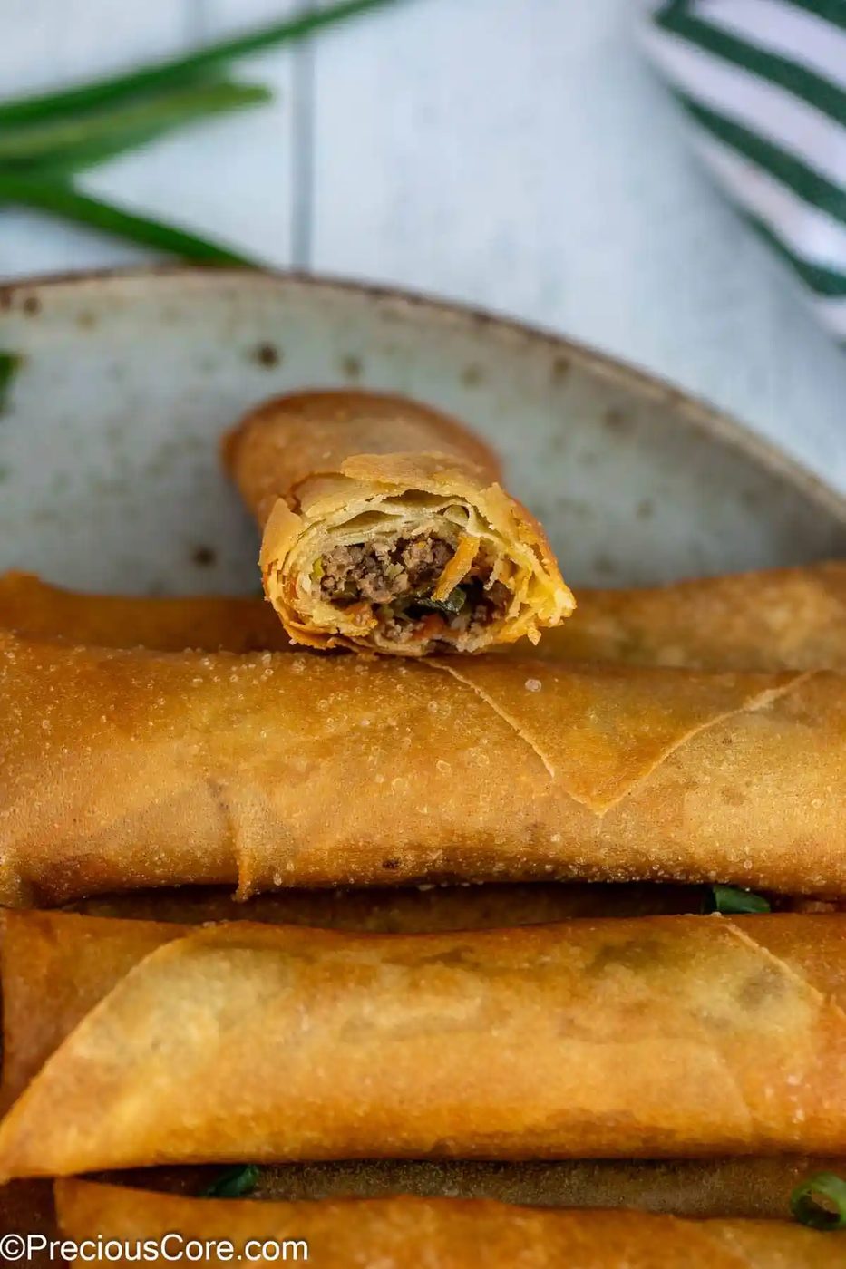 Bite taken out of spring roll with beef filling.