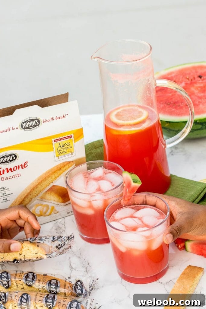 Hand holding a cup of watermelon lemonade, hand holding a cookie