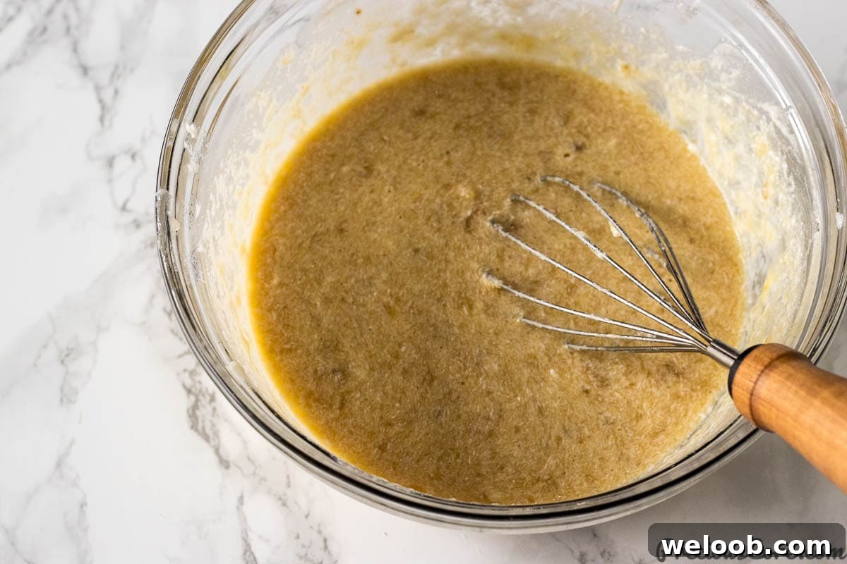 Mixing wet ingredients for Easy Moist Banana Bread Recipe