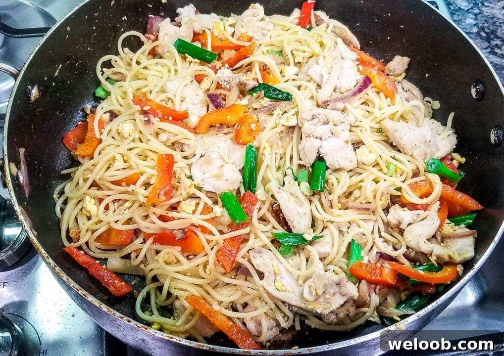 Stir fry with spaghetti and chicken in a pan