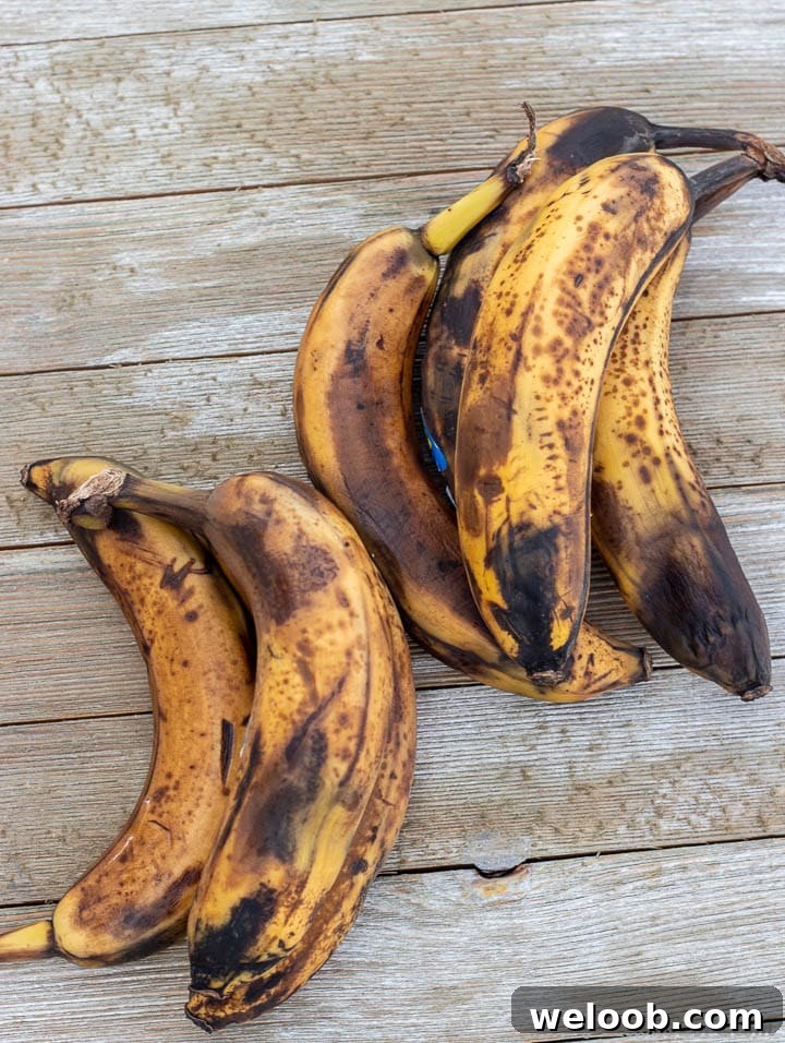 Overripe bananas on wooden surface.