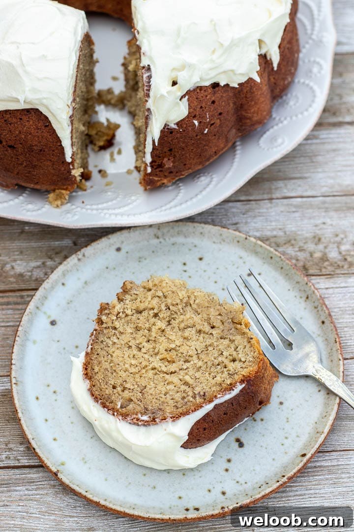 Slice of banana bundt cake with cream cheese frosting.
