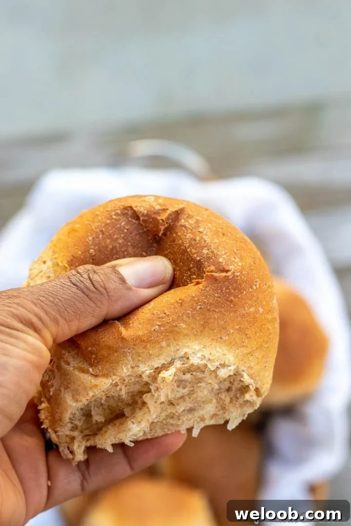 Hand pressing on a soft dinner roll.