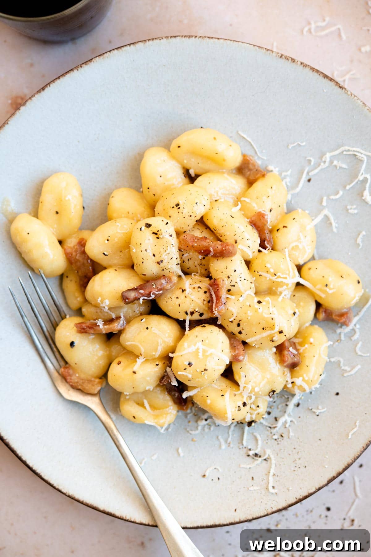 An overhead shot of a plate of gnocchi with carbonara sauce