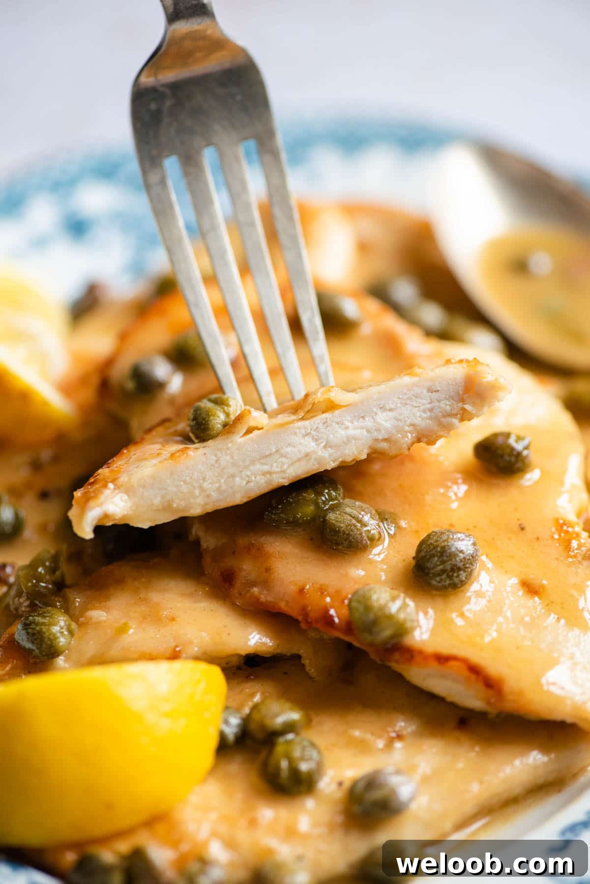 A piece of chicken piccata on a fork