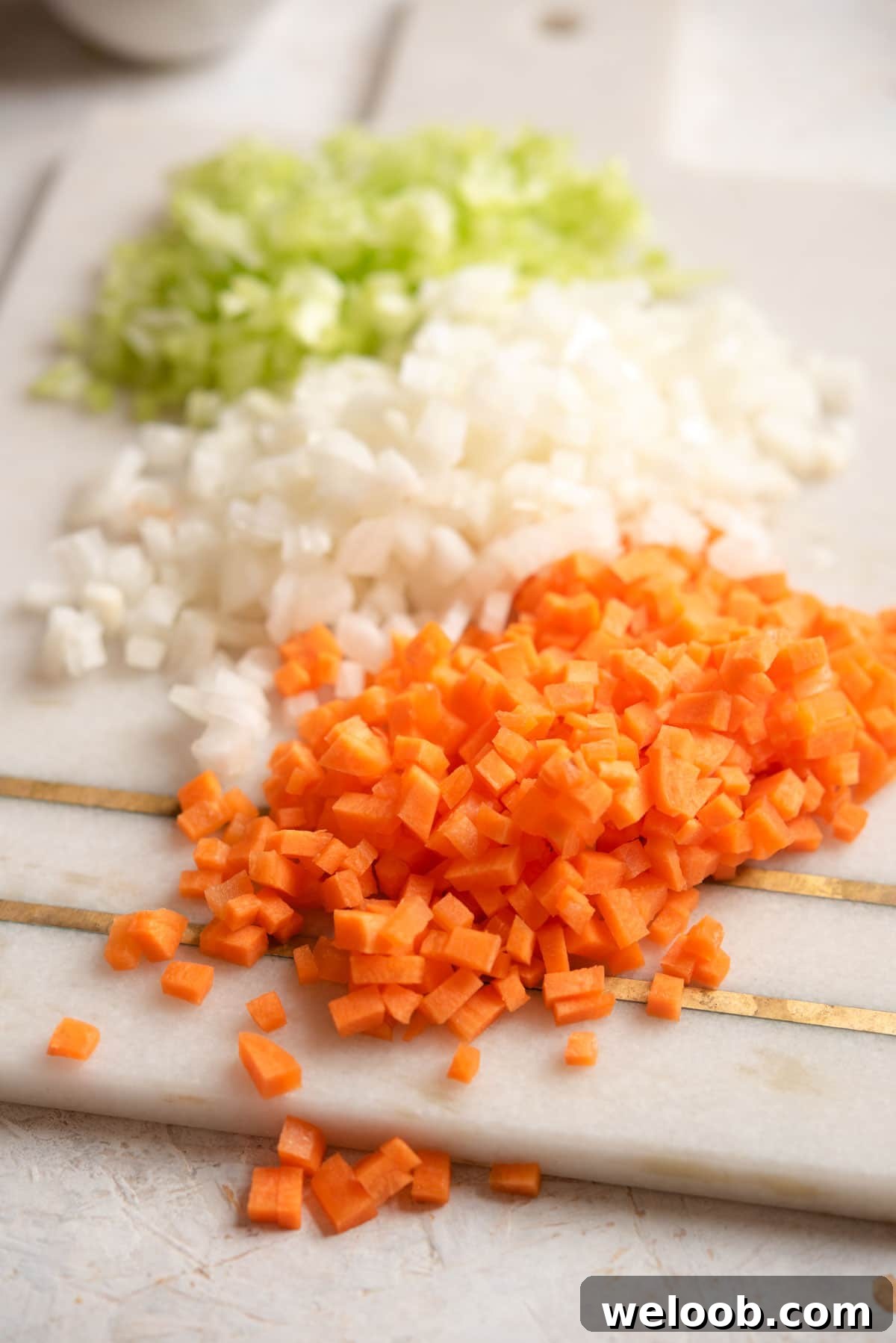 A close up of finely chopped soffritto on a board