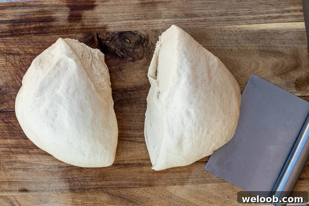2 portions of dough on a chopping board.
