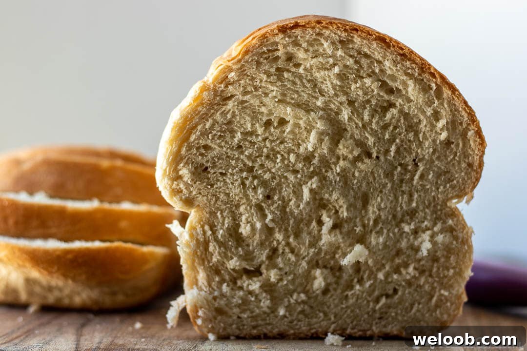 Half a loaf of homemade bread with bread slices on the side