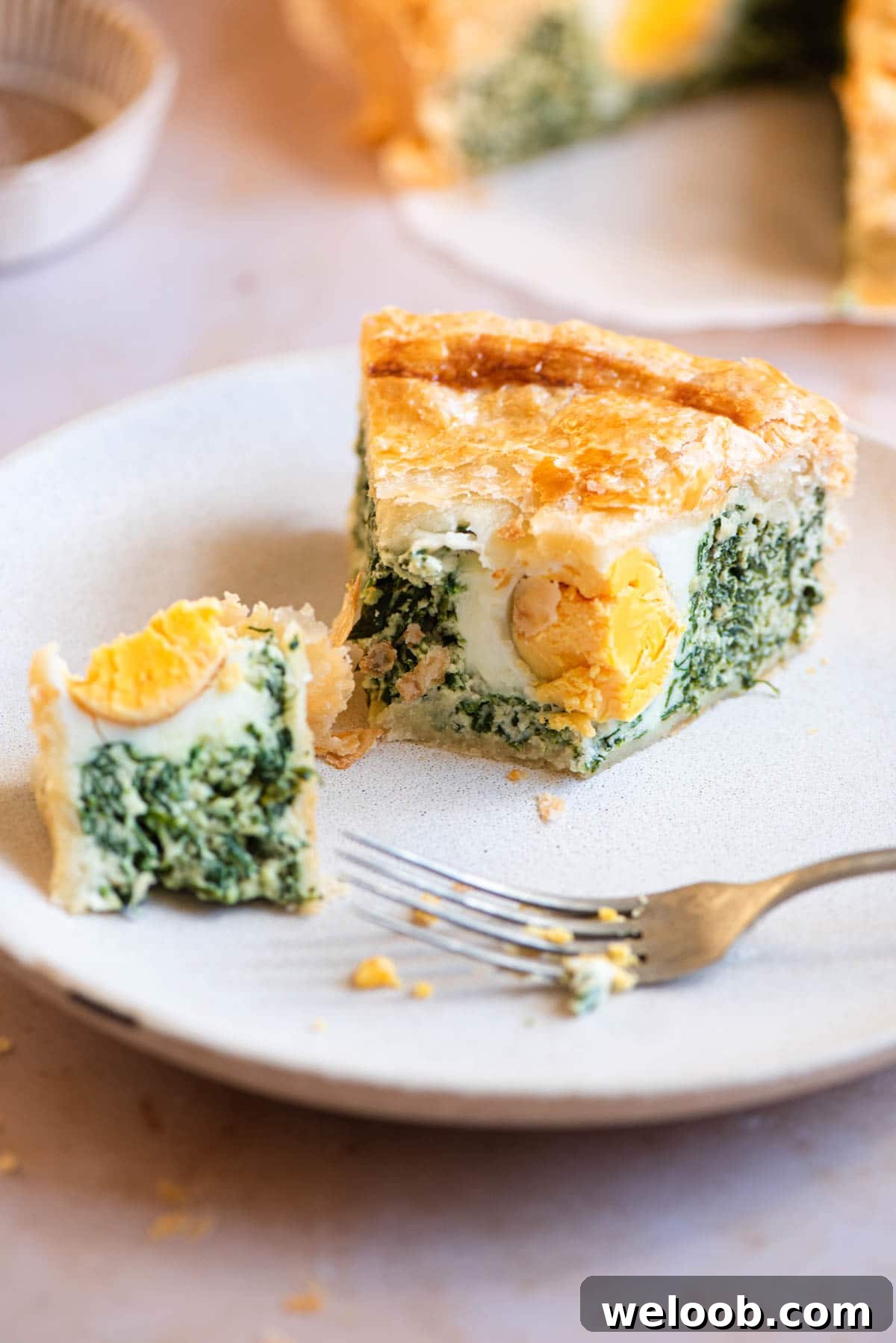 A slice of Torta Pasqualina on a plate cut in half