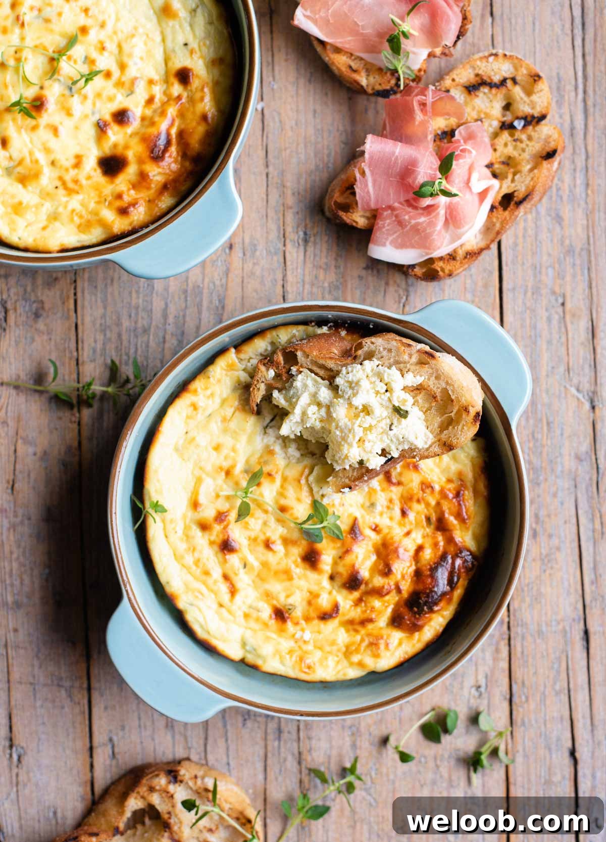 An overhead shot of baked ricotta in a blue dish with toasted bread at the side