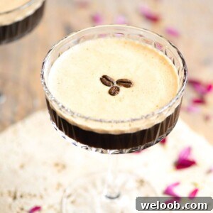 A close up of an espresso martini topped with coffee beans