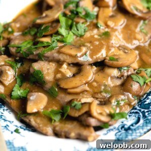 A close up of veal marsala on a blue servings plate