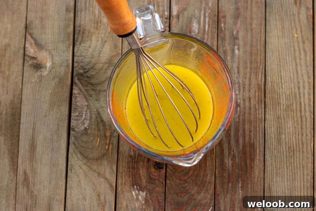 Simple lemon vinaigrette in a measuring cup.