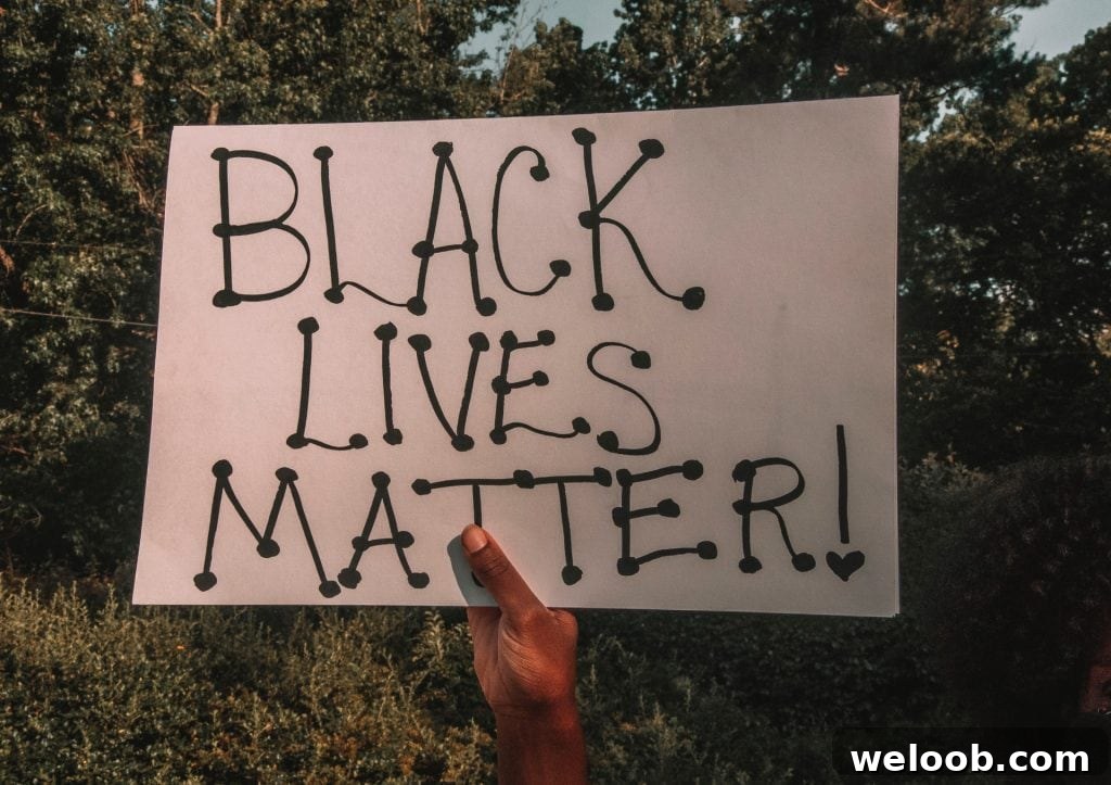 Black hand holding a "Black Lives Matter" placard