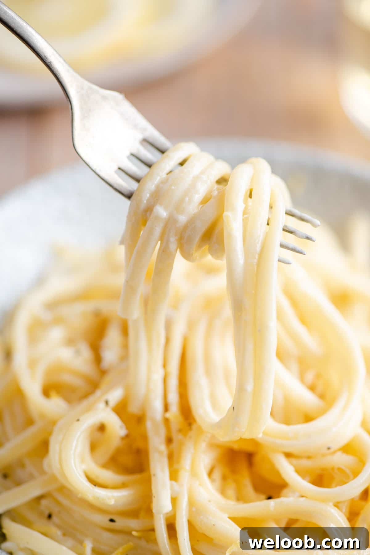 A close up of creamy lemon pasta on a fork