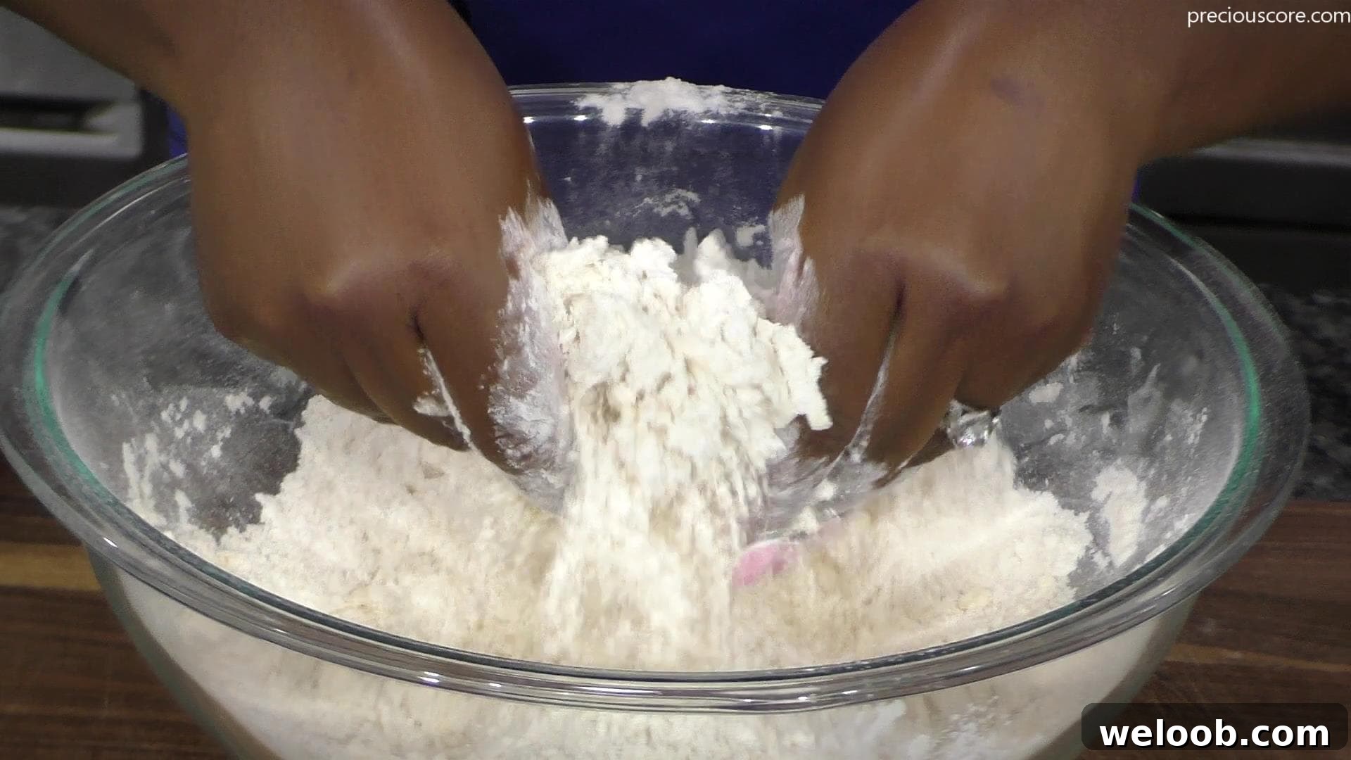 Hands mixing butter and flour together.