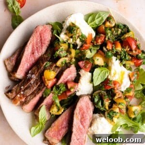 Steak tagliata on a plate with tomato and mozzarella salad