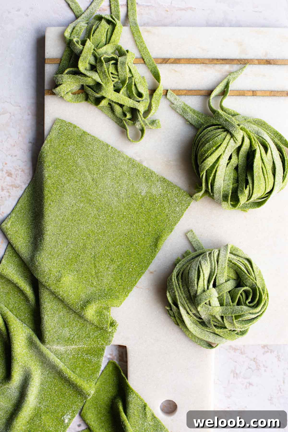 An overhead shot of spinach pasta dough cut into shapes on a light surface