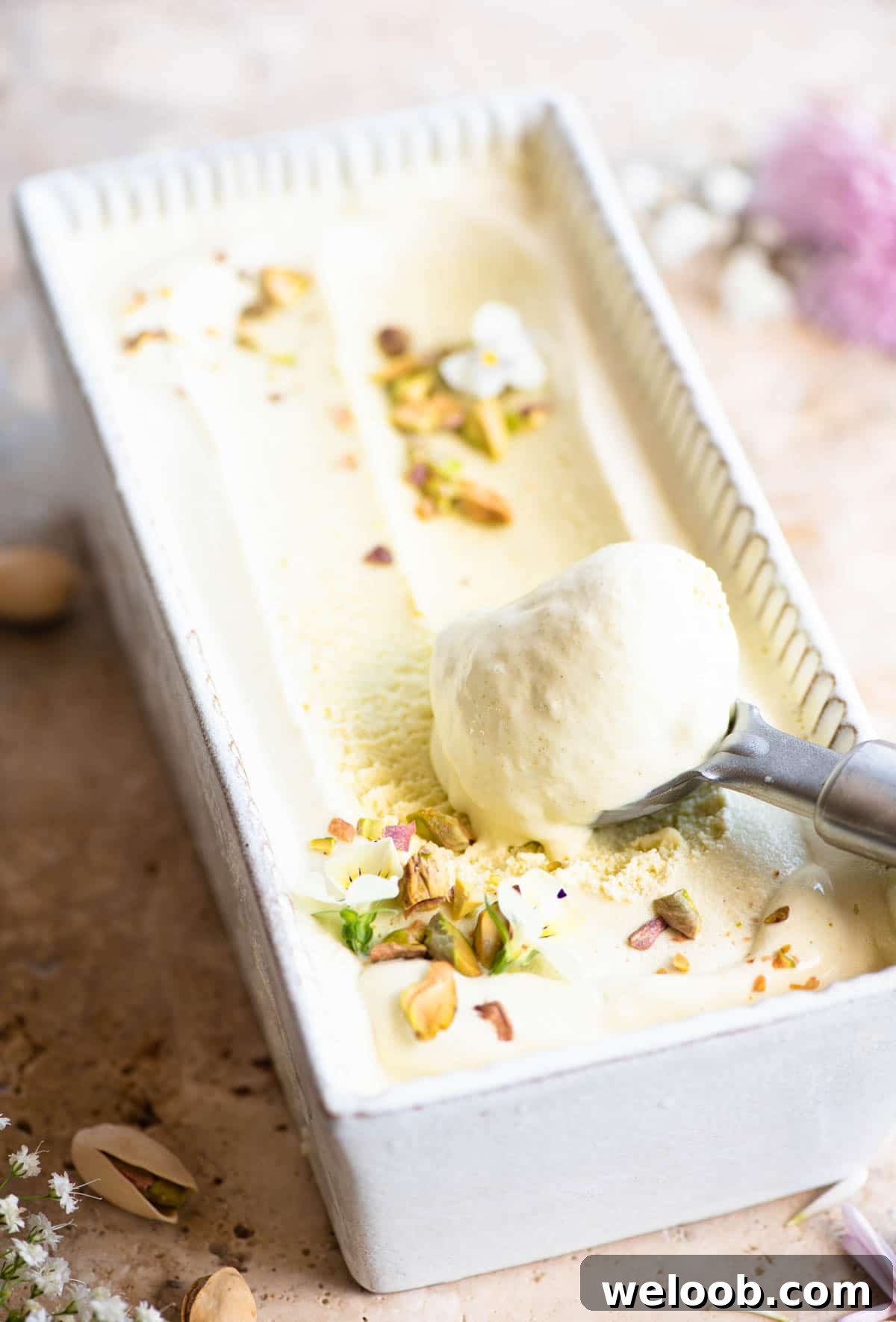 Pistachio ice cream in a loaf dish with a sccop of ice cream at one end