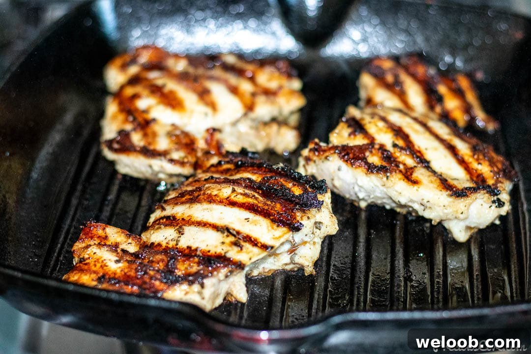 Chicken thighs grilling in grill pan.