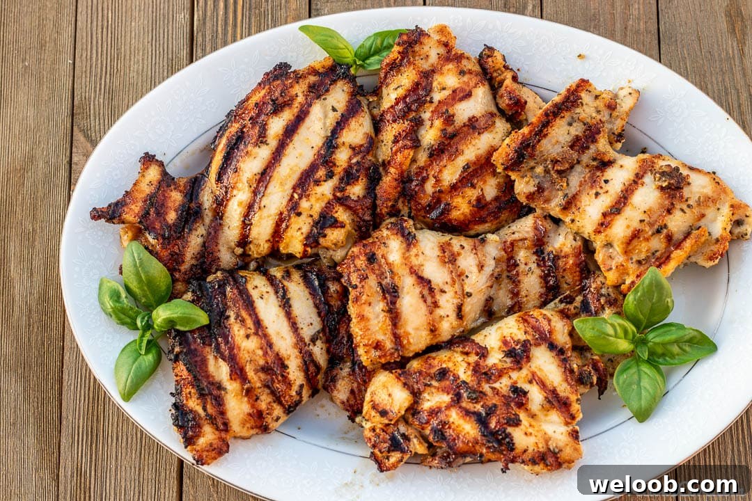 Platter of grilled chicken thighs with grill marks.