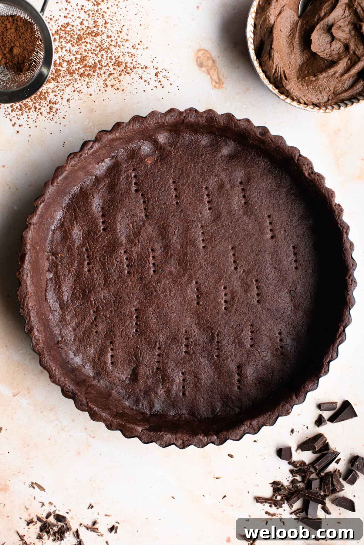 An overhead shot of chocolate pastry in a tart pan ready to be baked
