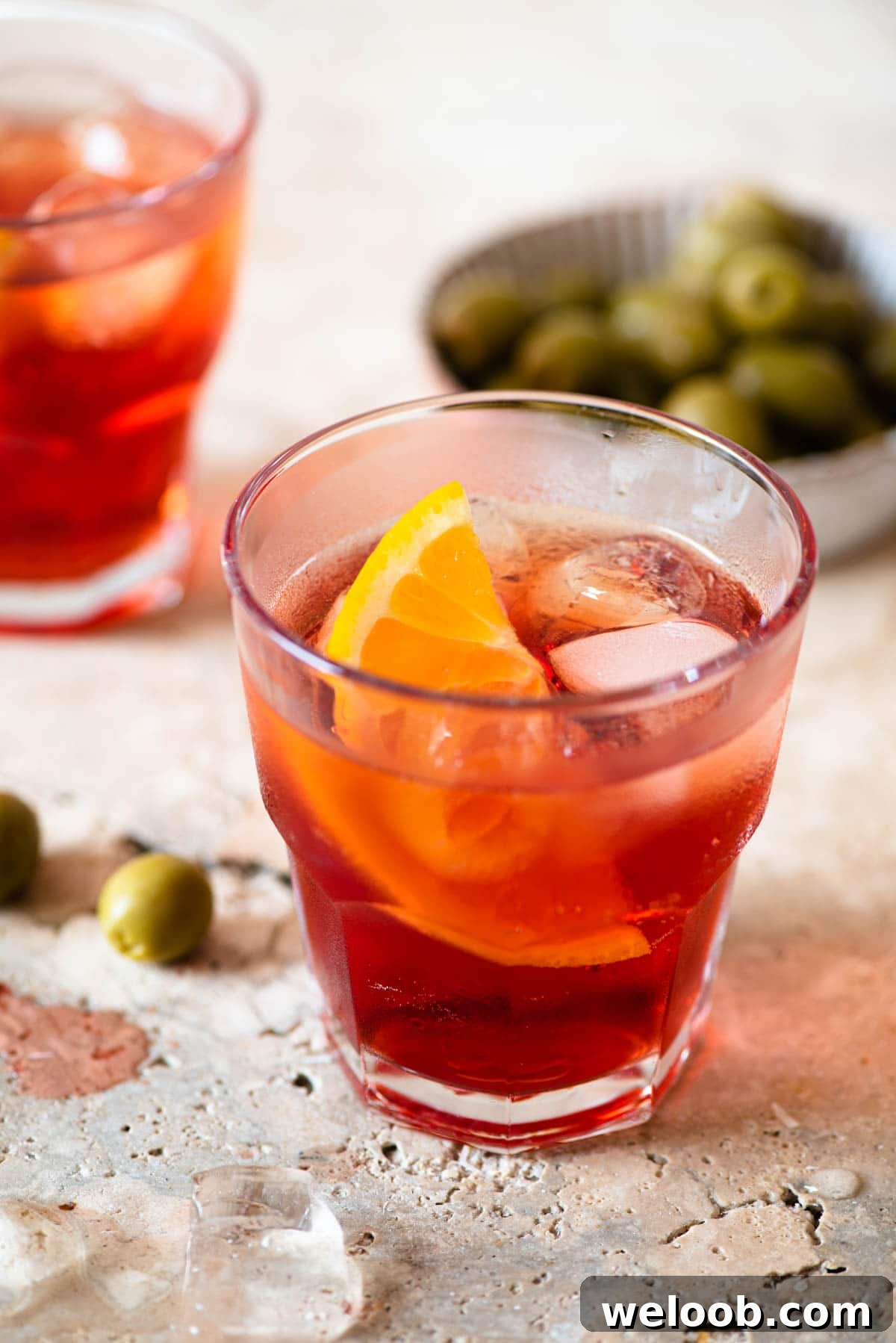 A close up of an Americano cocktail with a slice of orange