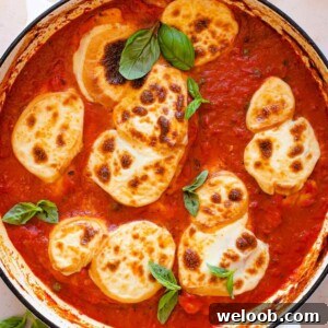 Smoked Scamorza Chicken Pizzaiola with Tomato and Herbs 9 An overhead shot of chicken pizzaiola in a pan topped with cheese