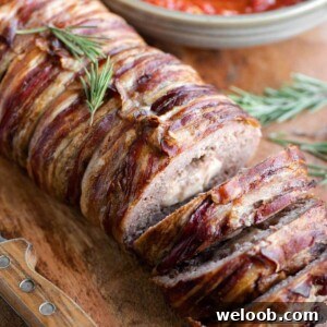 A close up of an Italian meatloaf wrapped in pancetta and stuffed with cheese