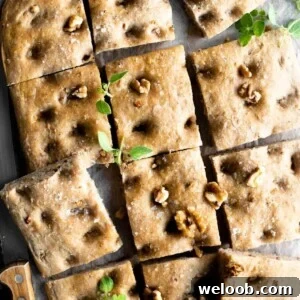 A close up of a walnut focaccia cut into squares