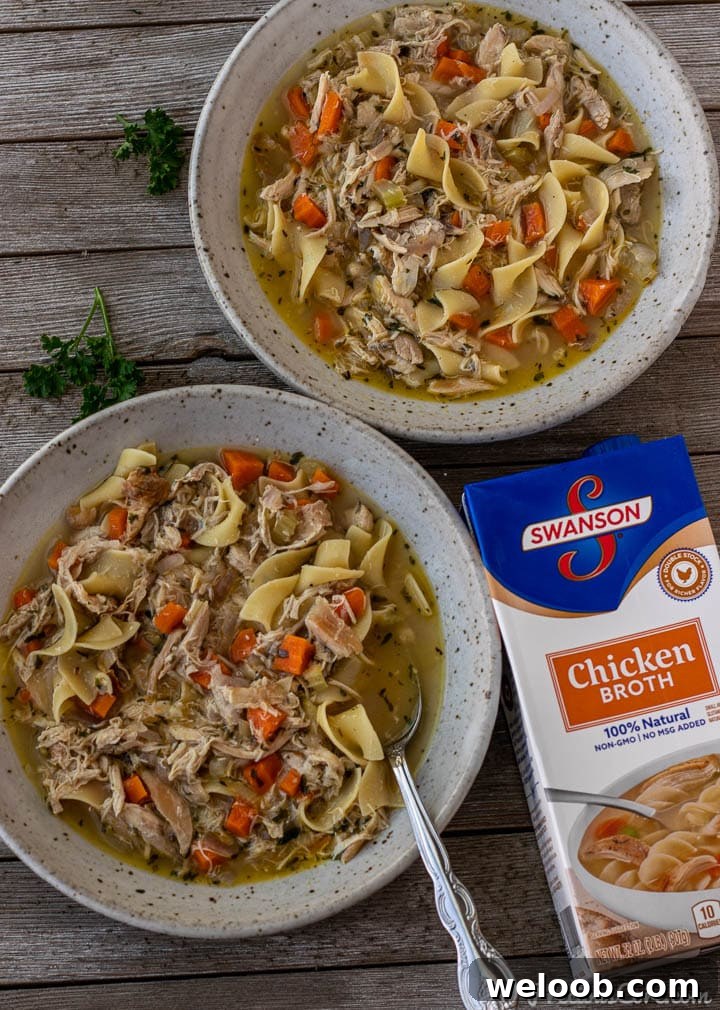 2 bowls of chicken noodle soup with a box of chicken broth on the side.