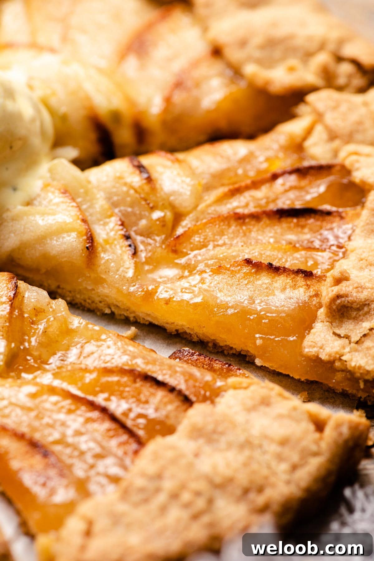 A close up of a slice of apple crostata with apricot jam