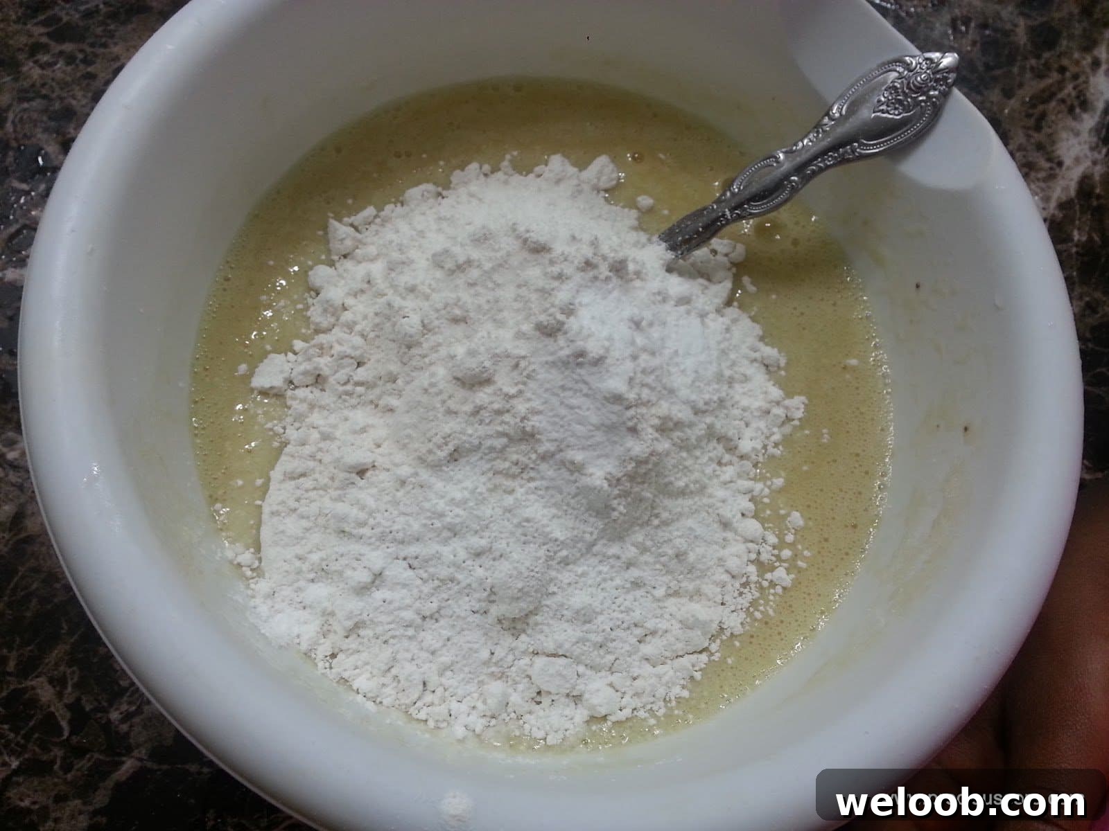 Pile of dry ingredients in a bowl of wet ingredients.