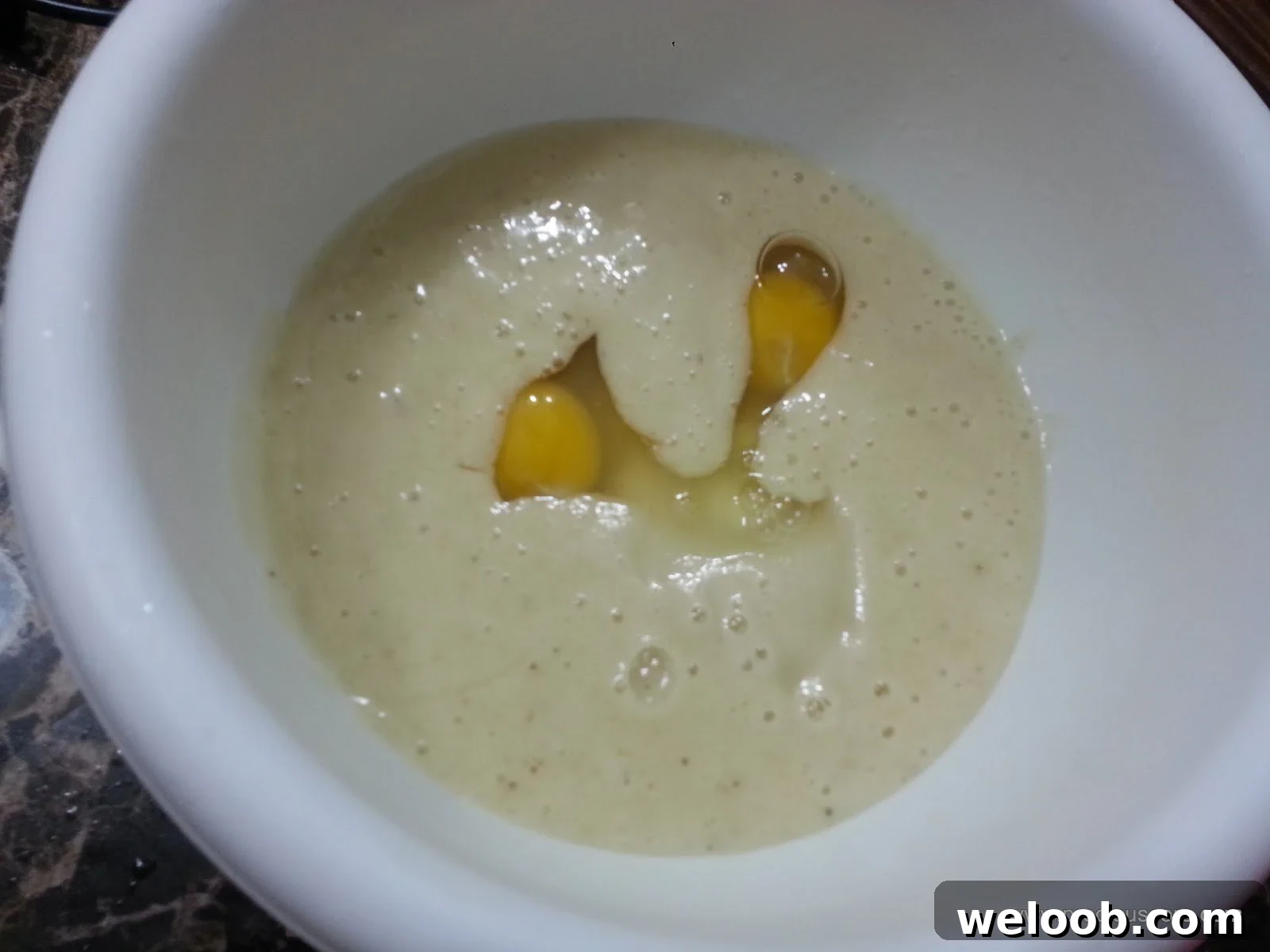 Eggs in a mixing bowl with a banana mixture.