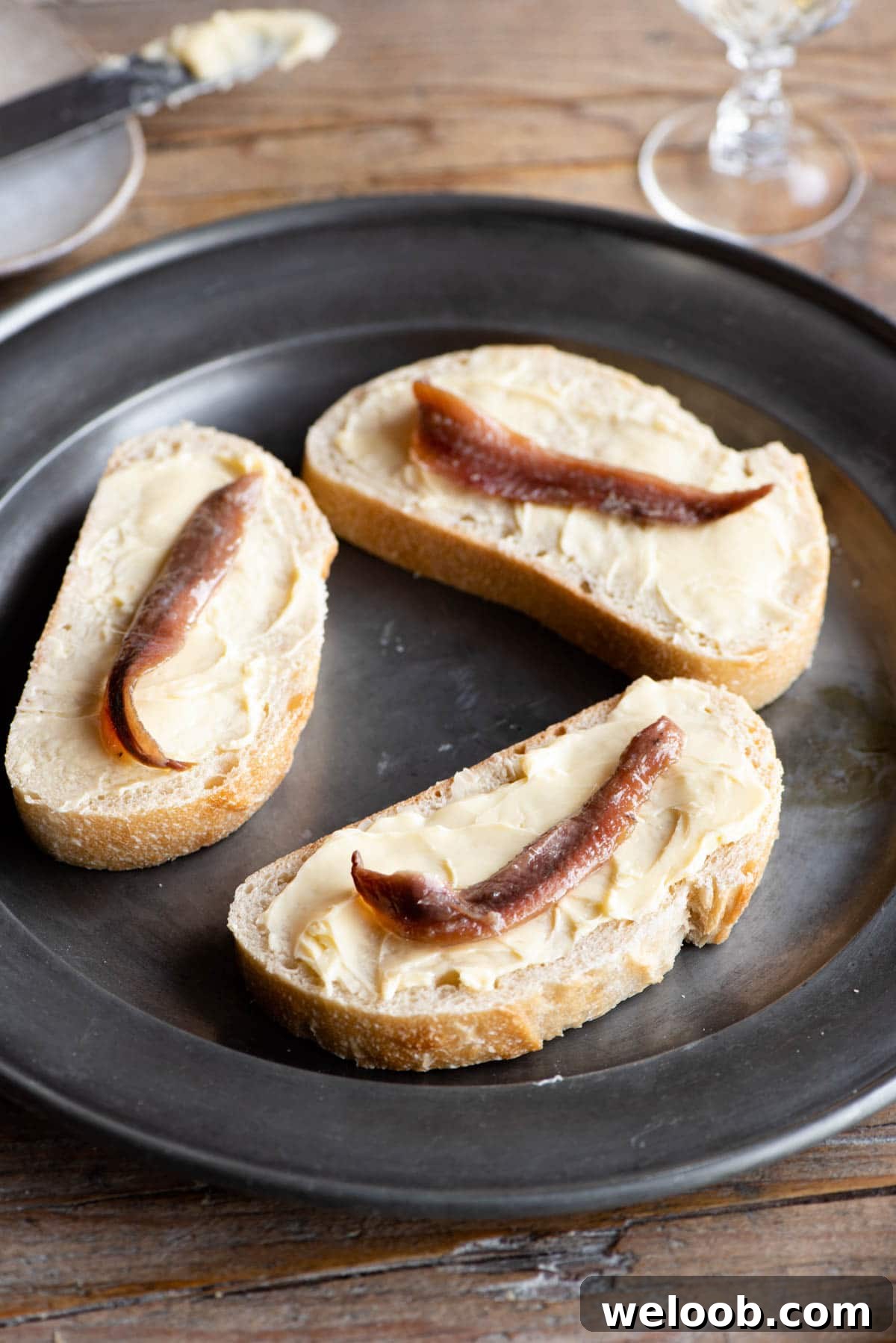Three slices of bread with butter and anchovies