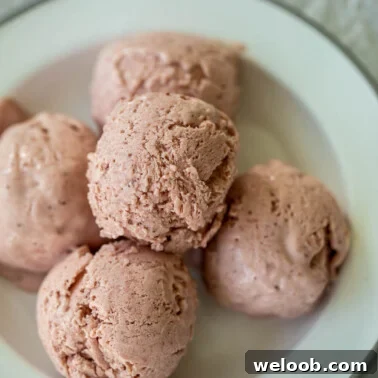 Scoops of no churn strawberry ice cream on a plate