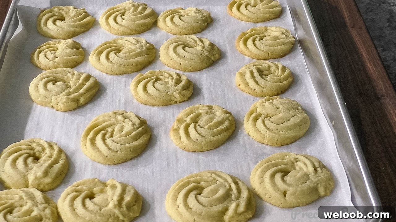Freshly bakes butter cookies on baking sheet.