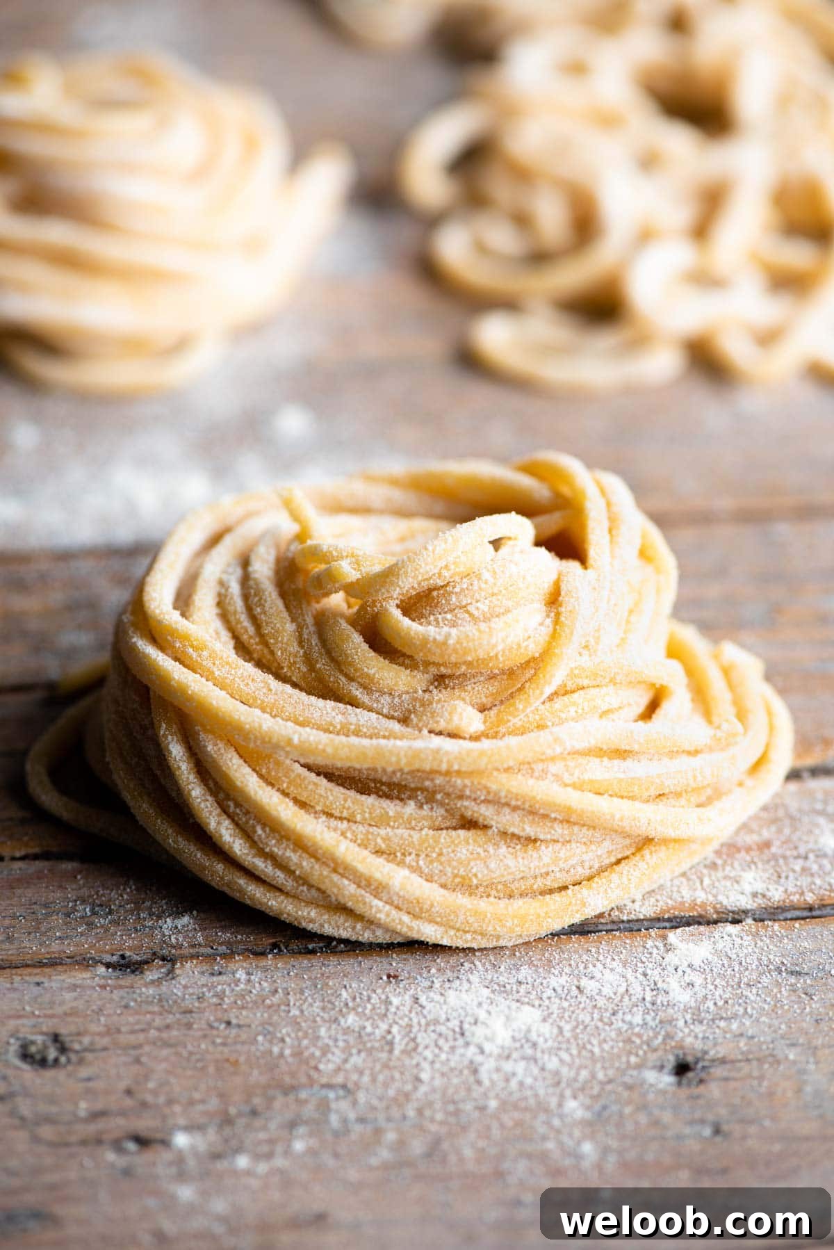 A nest of tonnarelli pasta sitting on a wooden surface