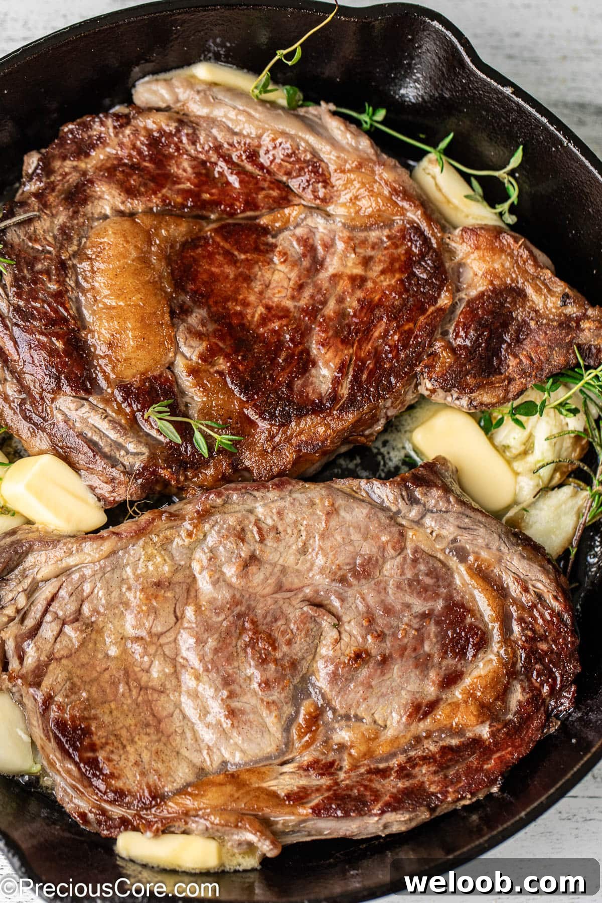 Perfect Pan-Seared Ribeye Steak with Crispy Crust and Juices 7 2 ribeye steaks in a cast iron skillet.