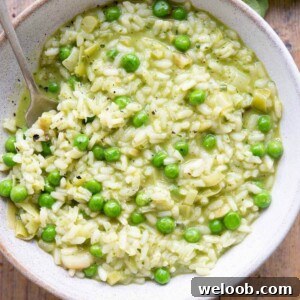 A close up of a bowl of risotto with pesto and peas