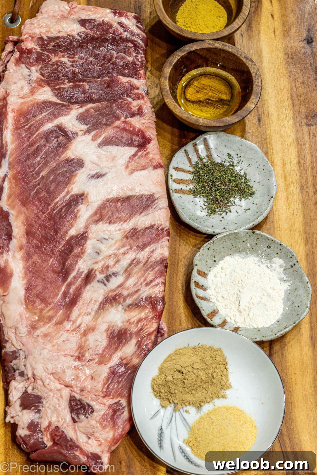 Raw ribs, spices, and salt on a chopping board.