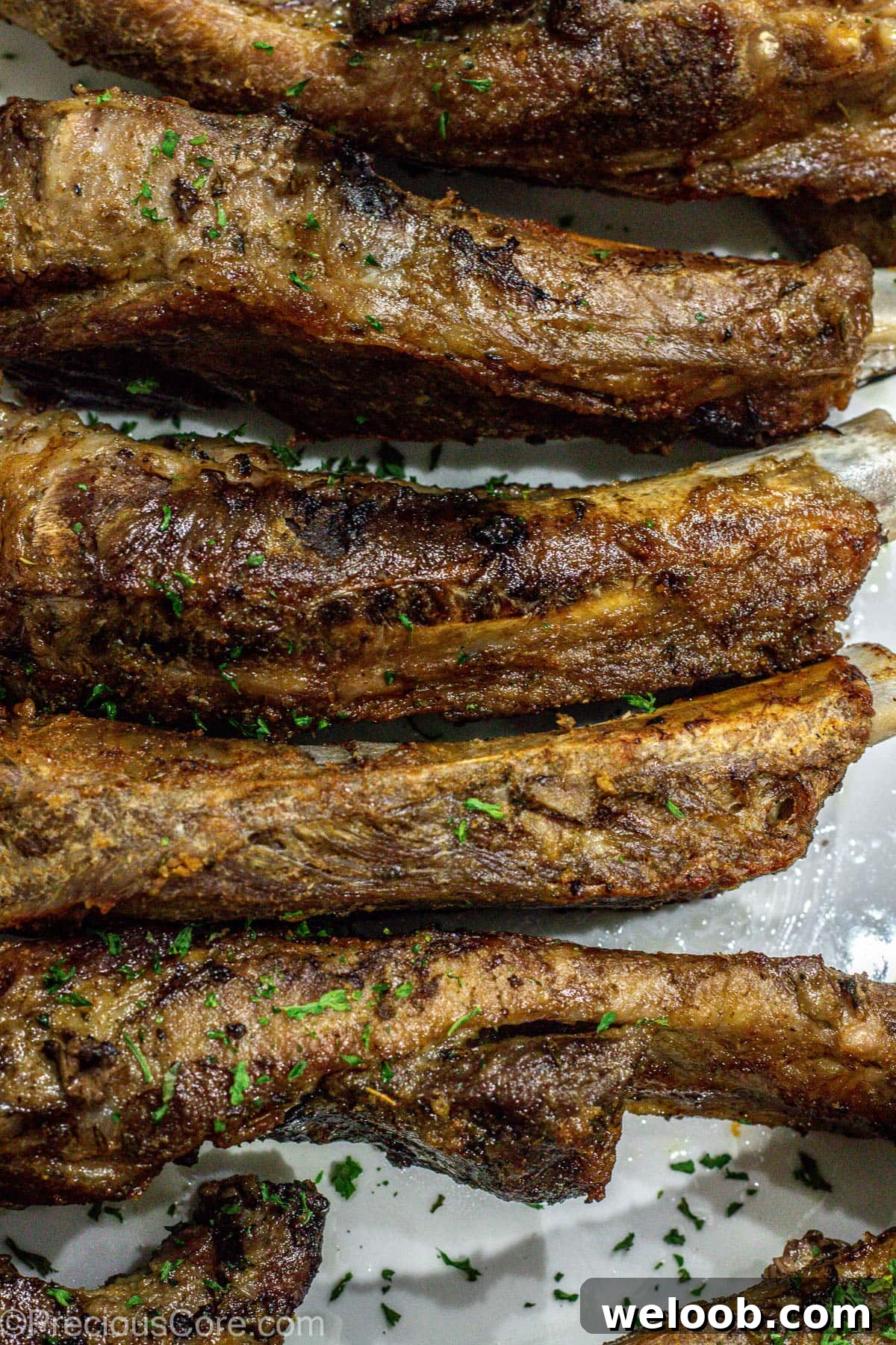 Broiled ribs on a white serving platter.