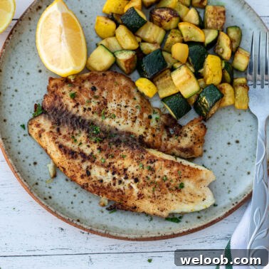 Square image of tilapia and zucchini on a plate.
