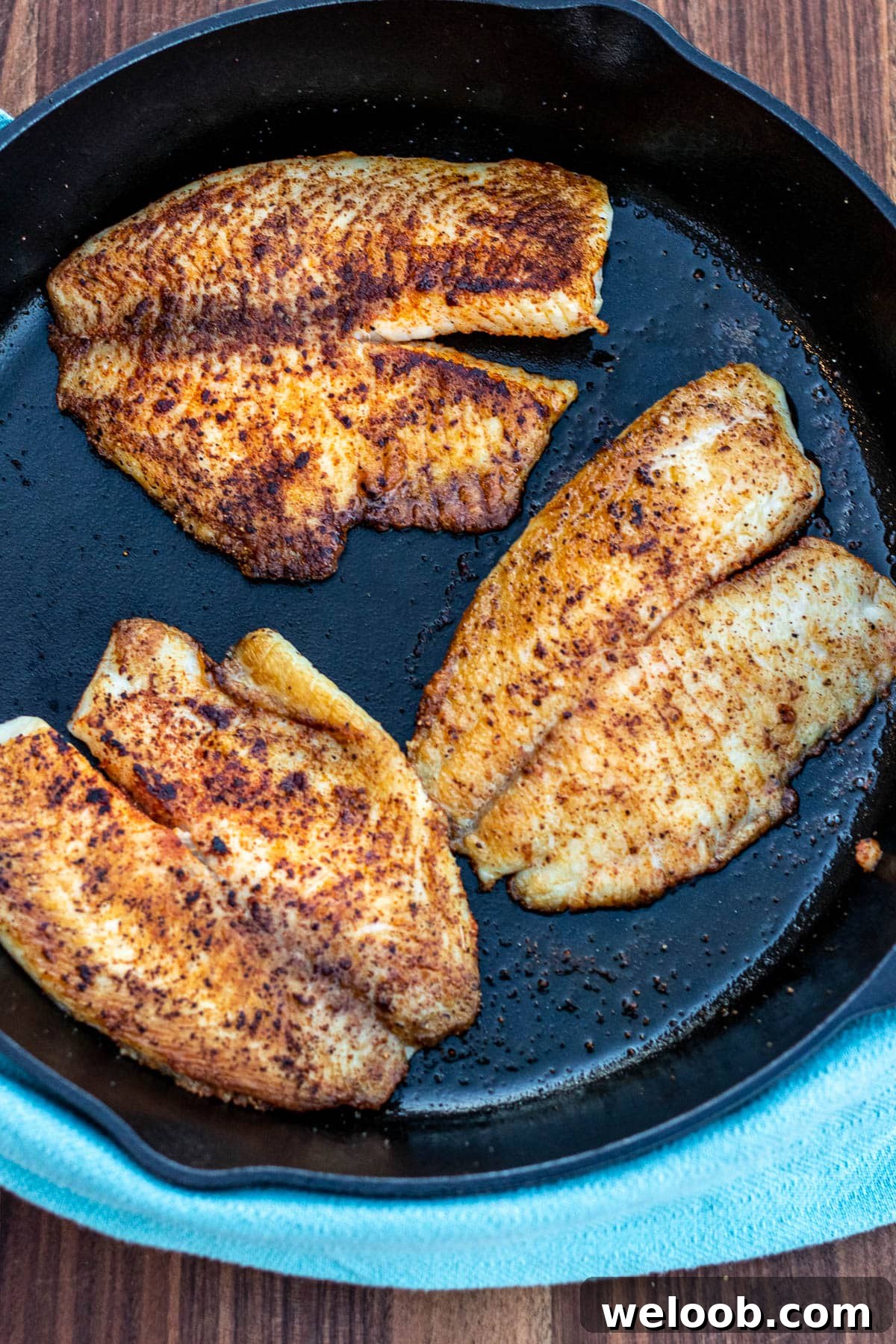 Tilapia fillets cooked in a cast iron pan.