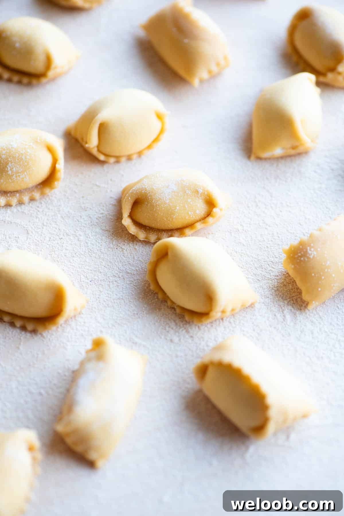 A close up side shot of homemade Agnolotti on a wooden board.