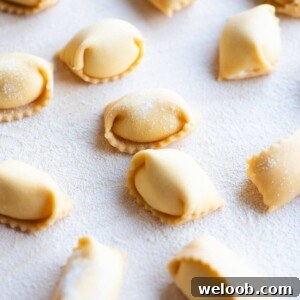 A close up cropped image of homemade Agnolotti on a wooden board.